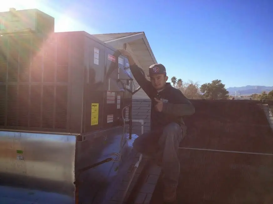HVAC technician performing HVAC Inspection on a rooftop unit in Graham